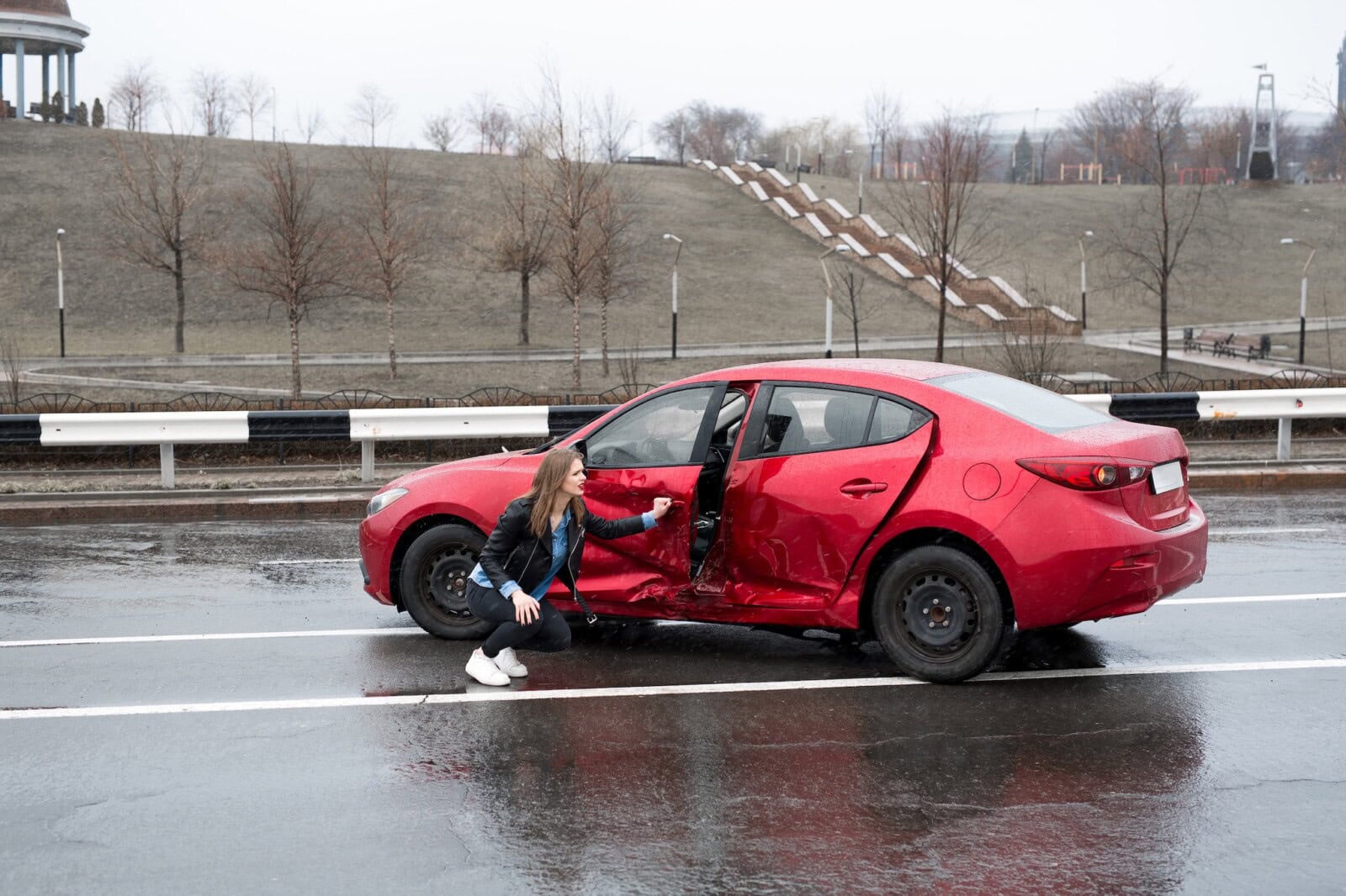 Woman sits near a broken car after an accident. call for help. car insurance.